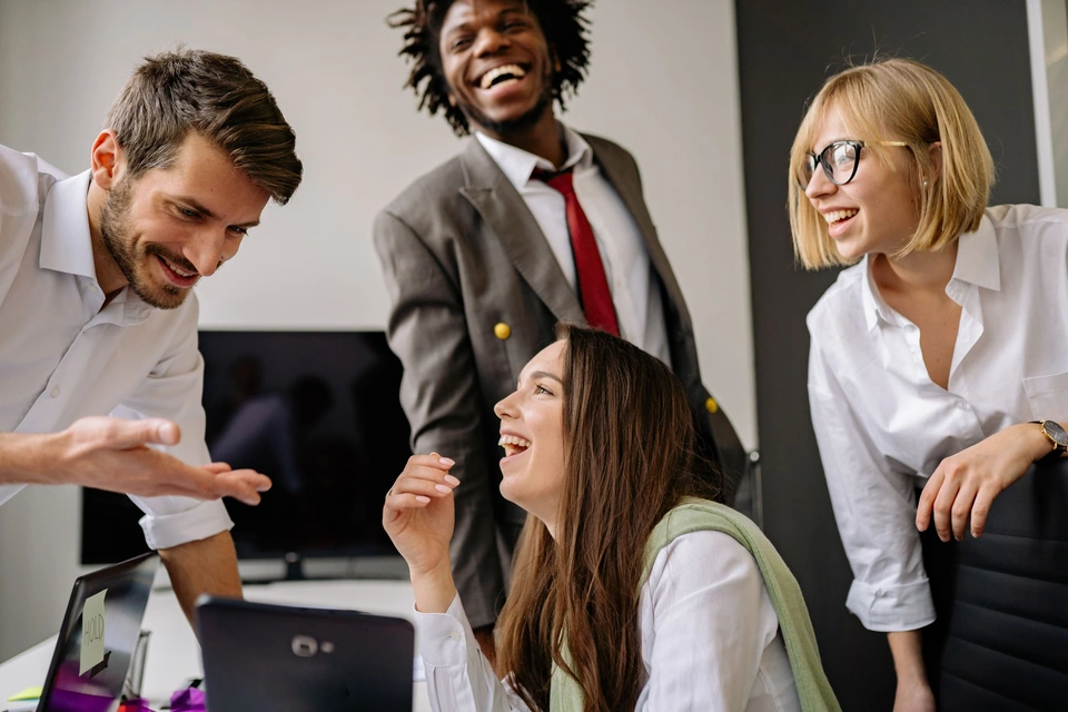 Colleagues laughing together during an office break